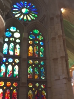 Stained glass amidst stonework in high-ceilinged church.